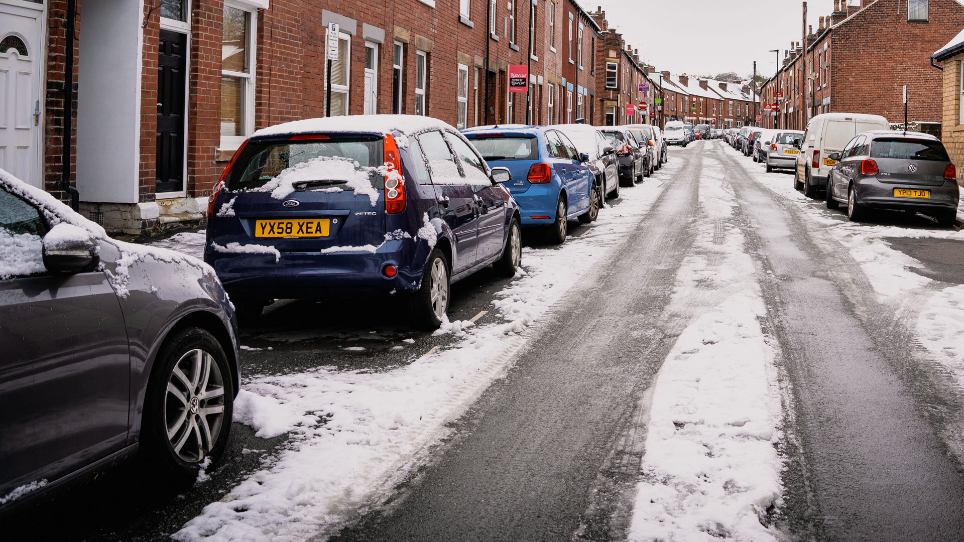 Cars parked on road in Winter snow